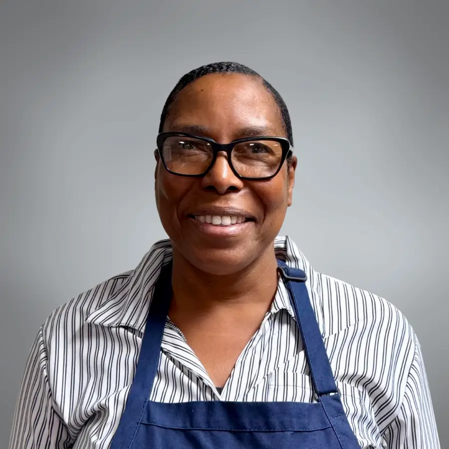 WAKJA - Black woman with glasses smiling at camera